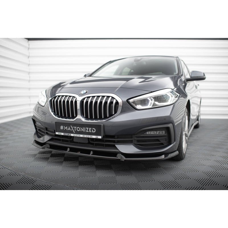Voiture BMW gris foncé vue de trois-quarts avant dans un studio.